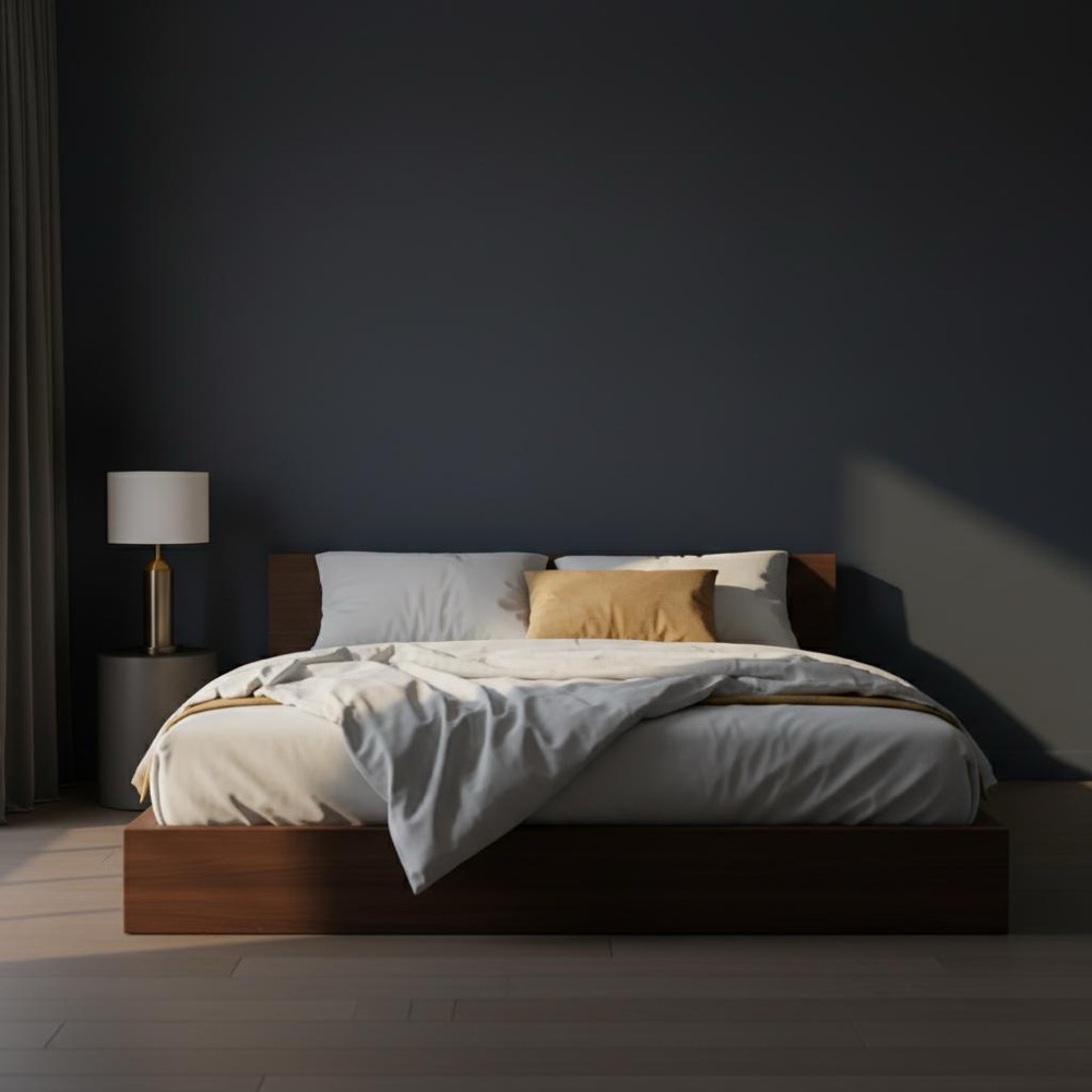 Minimalist dawn bedroom with empty bed, soft white sheets and blackout curtains ajar letting warm golden light in; navy walls and subtle gold accents to help sleep better.
